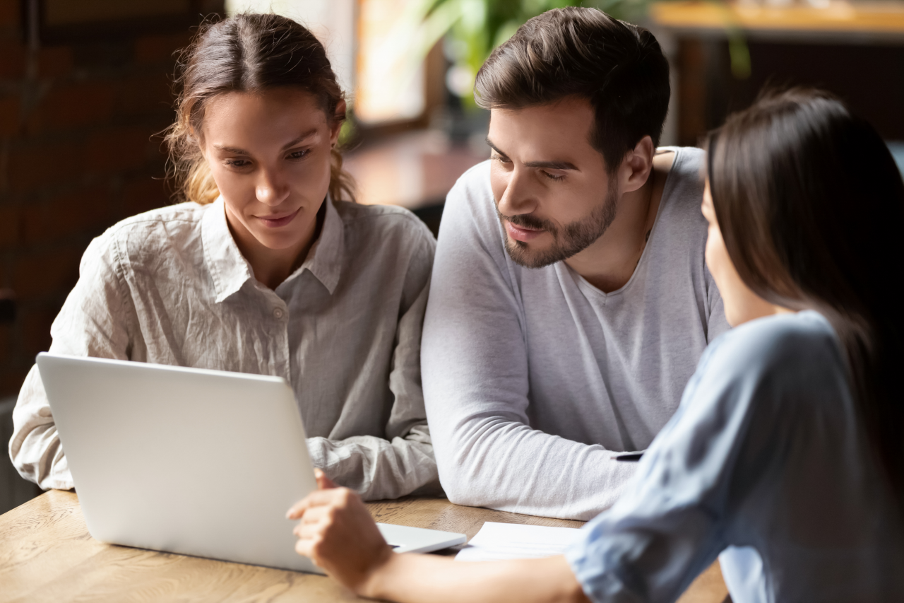 Three people looking at laptop
