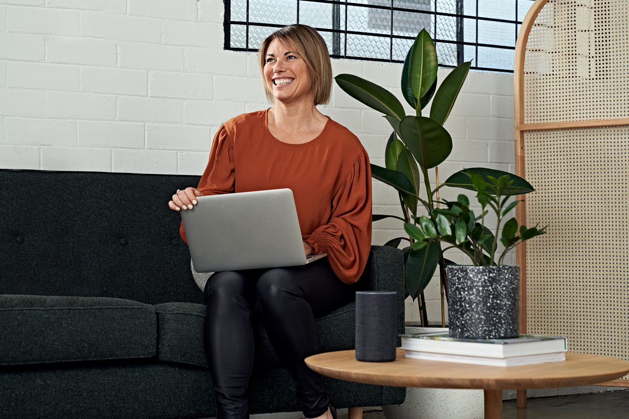 Woman sitting on couch with laptop